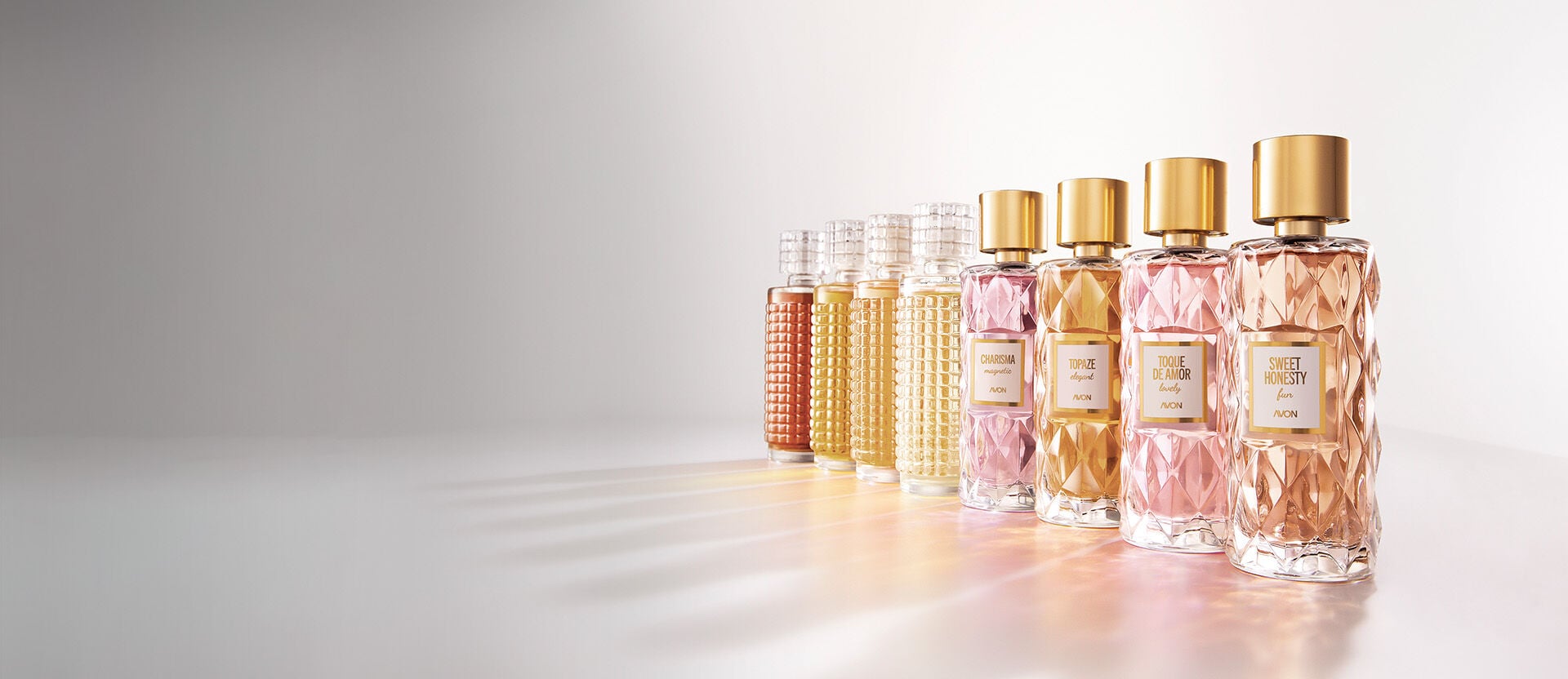 Frascos de Aquavibe Body Splash: Romã, Framboesa, Pretty Blue, Nectarina e Flor de Pêssego, Ameixa, Jabuticaba, Baby Smell, Lichia e Baunilha, Pitanga e Chipre, sobre fundo aquoso azul.