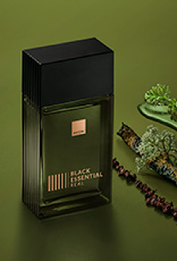 Fragrância Black Essential Real com ingredientes como pimentas e plantas, em fundo verde.