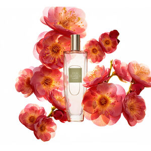 Frasco da fragrância Pur Blanca Noite, rodeada de flores avermelhadas, em fundo branco.