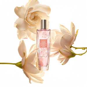 Frasco da fragrância Pur Blanca Gardênia, rodeada de flores em tom creme, em fundo branco.