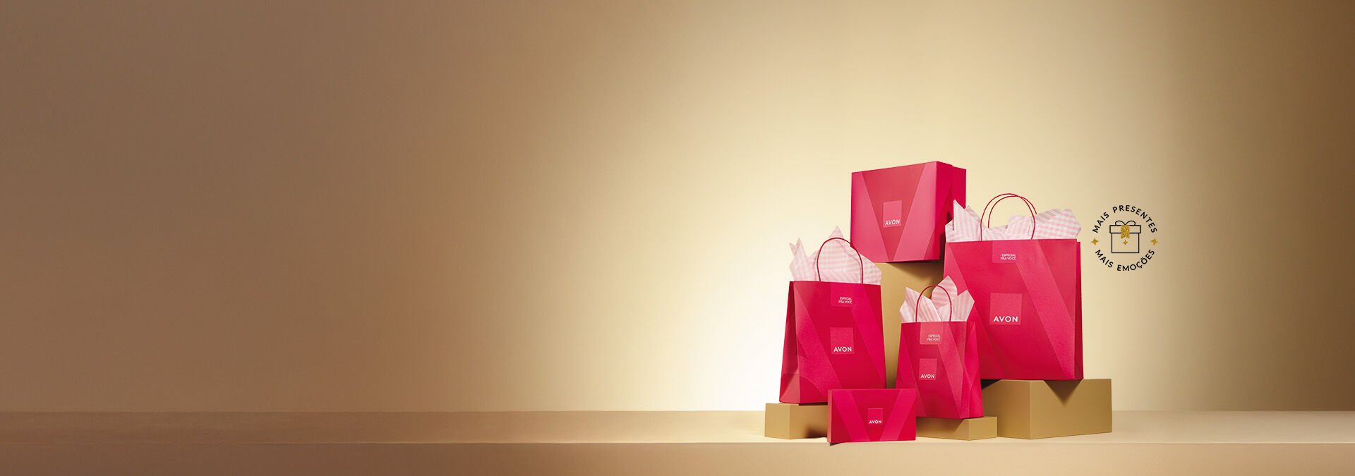 Banner com fundo bege degradê e elementos que incluem caixas e sacolas rosas da Avon sobre bases douradas. Texto: "Embalagens traduzem amor e cuidado. Presenteie com Avon."