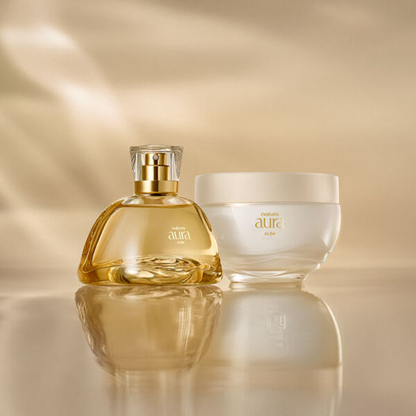 Frasco do Deo Parfum ao lado do Creme Corporal Natura Aura Alba sobre uma superfície dourada, com fundo suavemente iluminado. As embalagens são elegantes com detalhes em dourado.