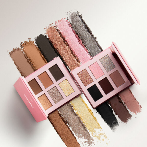Duas paletas de sombras Natura Faces abertas sobre fundo claro com amostras de pó. Os tons variam entre terrosos, rosa, dourado e preto, destacando acabamentos soft matte e cintilantes.