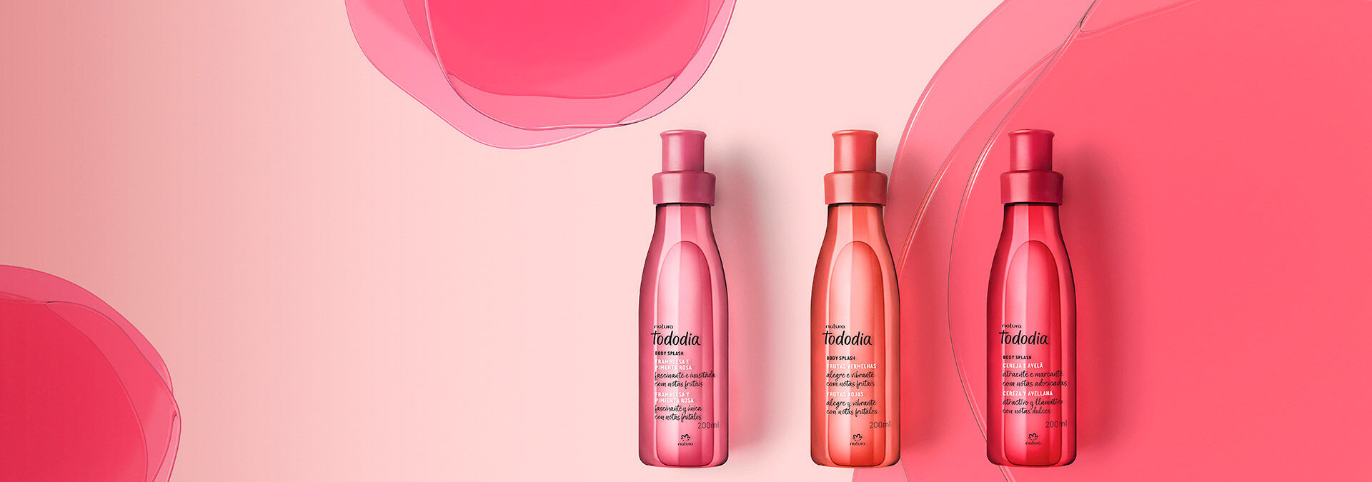 Fondo rosa con formas redondas, y al frente, tres body splash diferentes de Natura.