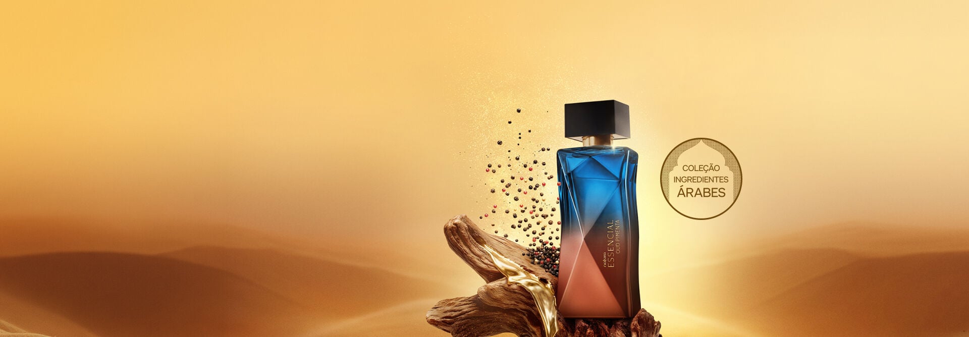 Frascos de Natura Essencial Oud Pimenta feminino sobre tronco com resina dourada em cenário desértico. Ao lado, pimentas dispersas no ar e selo "Coleção Ingredientes Árabes". 