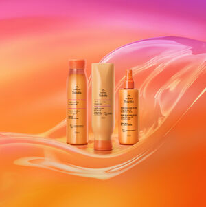 Três produtos Natura Tododia Manga Rosa e Água de Coco para cabelos. Um shampoo, um condicionador e um spray em embalagens alaranjadas brilhantes, dispostos sobre fundo ondulado laranja e rosa.