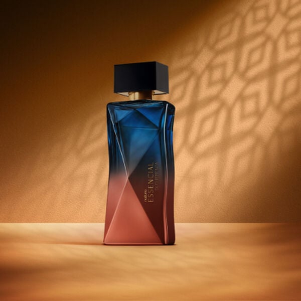Perfume feminino Natura Essencial Oud Pimenta em cenário terracota com sombras geométricas ao fundo.