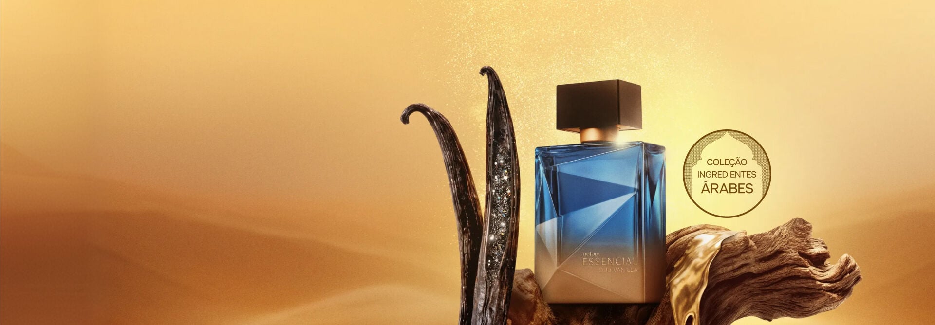Frasco azul do Deo Parfum Essencial Oud Vanilla Masculino sobre madeira com líquido dourado, ao lado de favas de baunilha em um cenário de deserto. À direita, o selo: "Coleção Ingredientes Árabes".