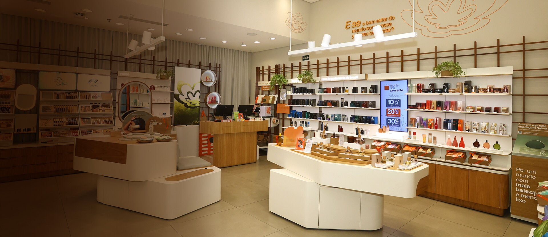 Foto do ambiente de uma loja Natura, com produtos e bancadas de experimentação.