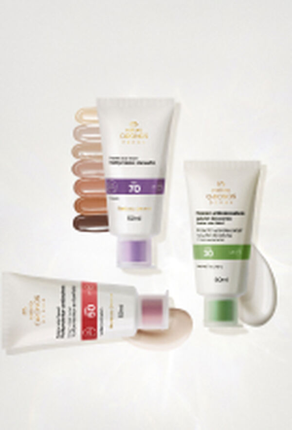 Bisnagas Chronos Derma: Multiprotetor Clareador, sobre texturas dos sete tons do produto, Protetor Antioleosidade, com textura cremosa, e Multiprotetor Antissinais, sobre textura, em fundo branco.