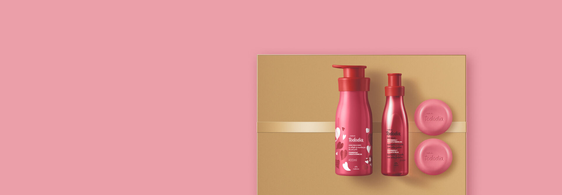 Fundo rosa-claro com o Kit Tododia Framboesa e Pimenta Vermelha sobre caixa dourada