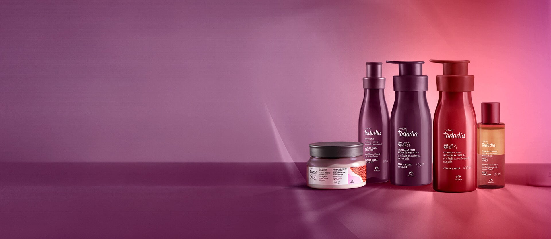 1 Creme Amanteigado Corporal Perfumado, 1 Body Splash e 1 Creme Nutritivo para o Corpo Tododia Cereja Negra e Praliné ao lado de 1 Creme Nutritivo para o Corpo e 1 Óleo Bifásico Tododia Cereja e Avelã.