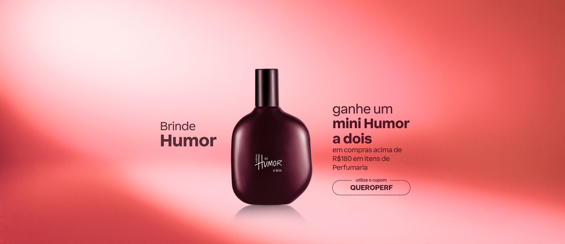 Imagem com fundo vermelho degradê com fragrância Humor a Dois. Texto: "Brinde Humor: ganhe um mini Humor a dois em compras acima de R$180 em itens de Perfumaria". Cupom: QUEROPERF.