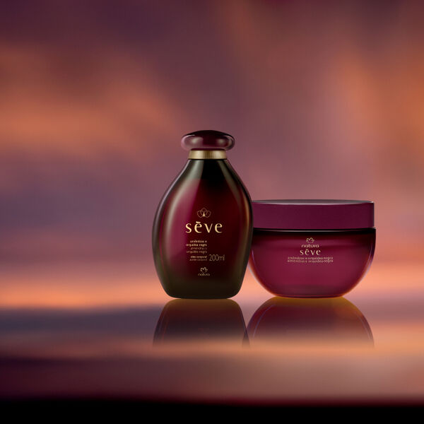 Natura Sève Óleo Desodorante e Creme Desodorante Corporal Perfumado Amêndoas e Orquídea Negra, com frascos em tons de roxo, destacam-se sobre fundo em tons de violeta e laranja.