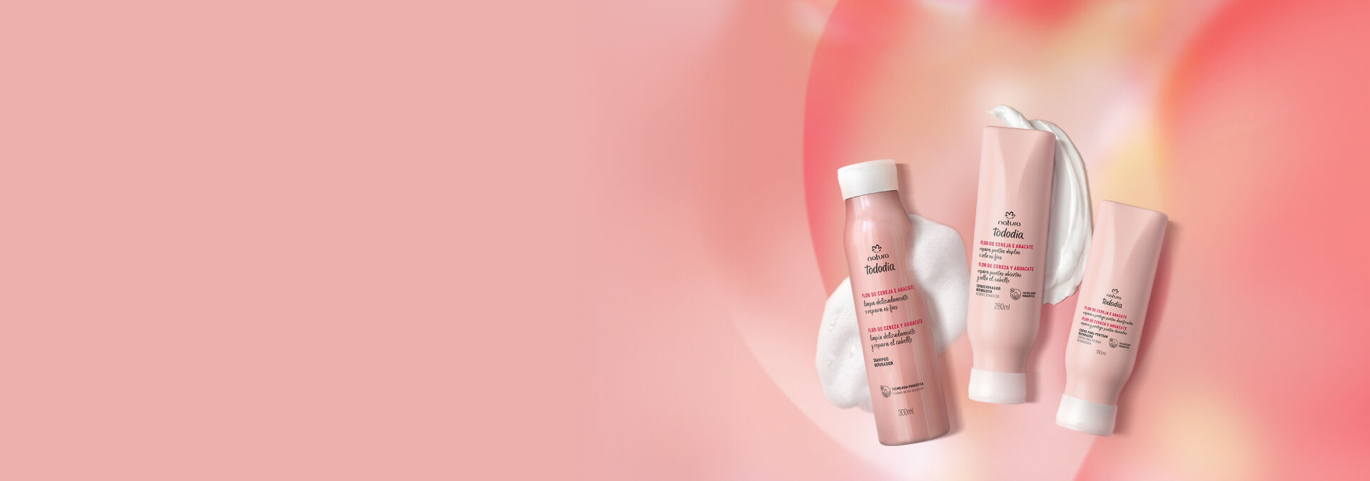 Foto do Shampoo, Condicionador e Creme para Pentear hidratante Tododia Flor de Cereja e Abacate, sobre fundo degradê rosa.