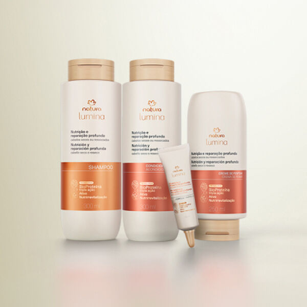 Quatro produtos da linha Natura Lumina Nutrição e Reparação Profunda alinhados sobre fundo neutro: Shampoo, Condicionador, Creme de Pentear e ampola de tratamento à frente.
