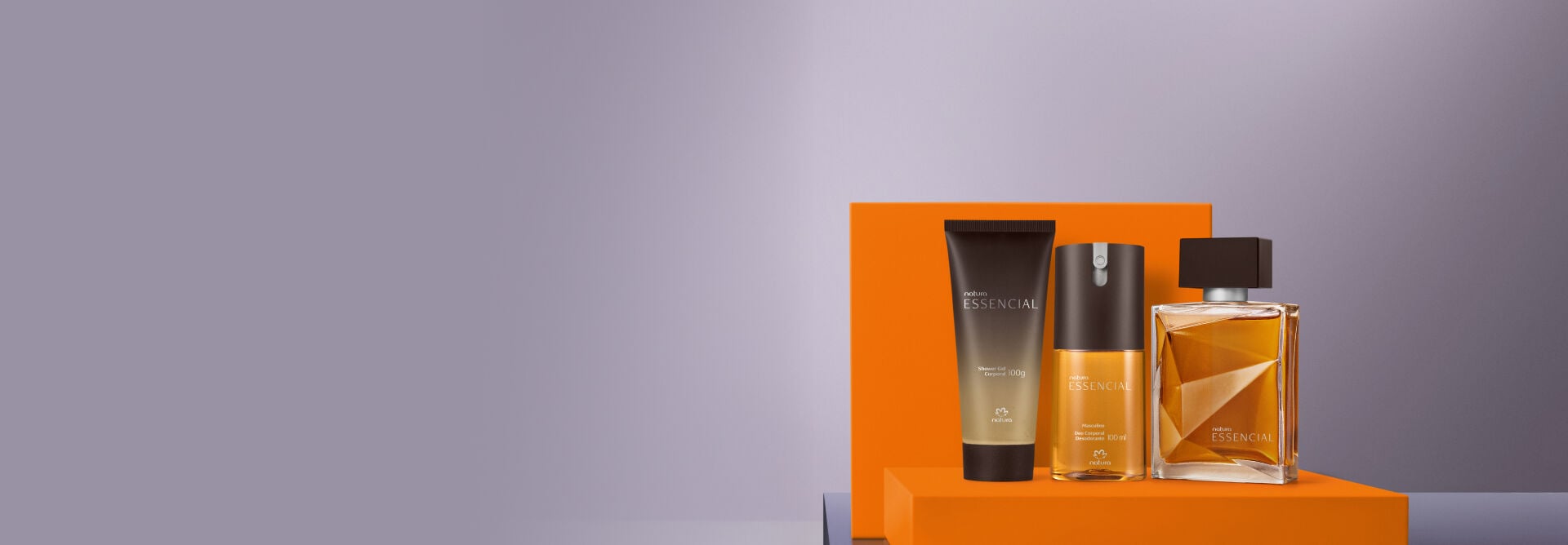 presente Natura Essencial Masculino, apoiado sobre caixa laranja e com a tampa apoiada no fundo, ambos em fundo cinza