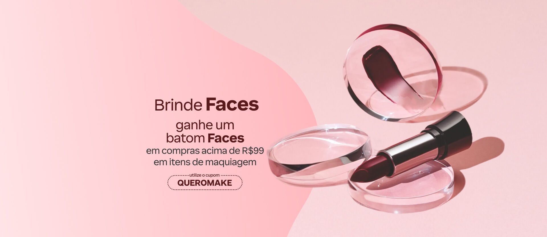 Fundo rosa com batom vinho aberto sobre blocos de acrílico transparentes. Texto: Brinde Faces: ganhe um batom Faces em compras acima de R$ 99 em itens de Maquiagem. Cupom: QUEROMAKE. Botão: Eu quero. 