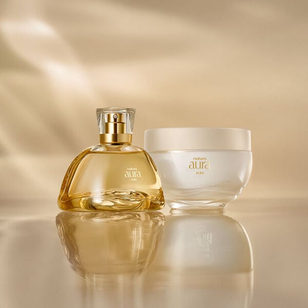Frasco do Deo Parfum ao lado do Creme Corporal Natura Aura Alba sobre uma superfície dourada, com fundo suavemente iluminado. As embalagens são elegantes com detalhes em dourado.