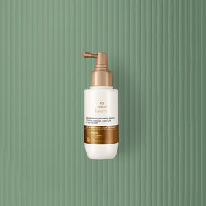 Embalagem creme com tampa e rótulo dourados de Shampoo de Tratamento Antissinais Natura Lumina. Fundo em verde com listras verticais.