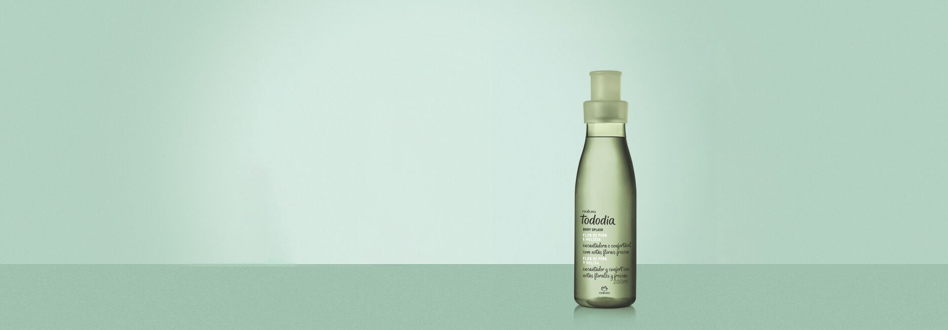 Itens Tododia Flor de Pera e Melissa: Body Splash, Creme para o Corpo e Sabonete Líquido sobre superfície verde, em fundo verde-claro.