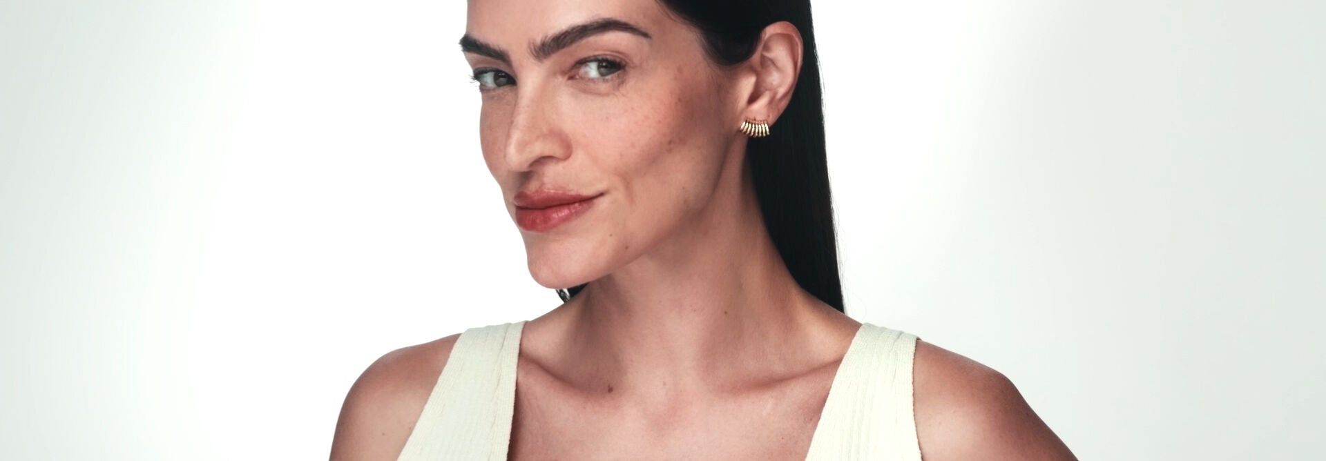 Sabonete em Pó Enzimático Limpeza Uniformizadora, Multiprotetor Clareador FPS 70 e Sérum Intensivo Multiclareador envoltos por esfera translúcida roxa, em fundo branco com selo Aprovado por Dermatologistas. 