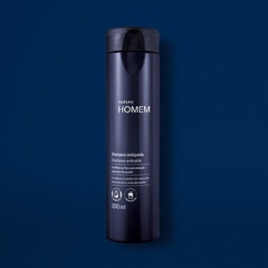Novo Shampoo Antiqueda Natura Homem aparece em destaque no centro da tela sobre fundo azul-marinho.
