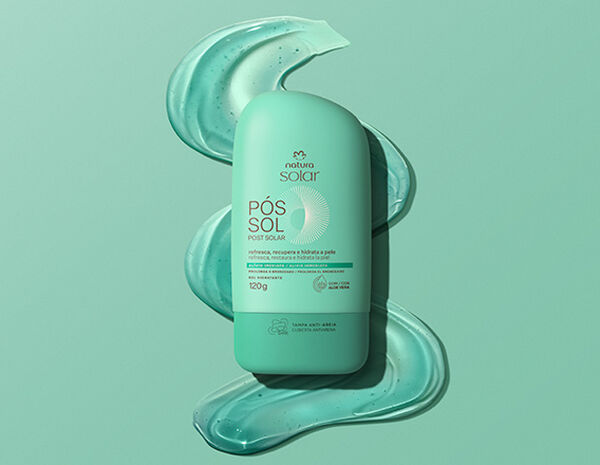 Embalagens Natura Solar Facial FPS 50 creme e verde, Corporal FPS 50 laranja e Pós-Sol verde, sobre grafismo semi-circular em laranja e creme. À direita, selo Tecnologia Bioproteção sobre foto de textura cremosa sobre ombro feminino.