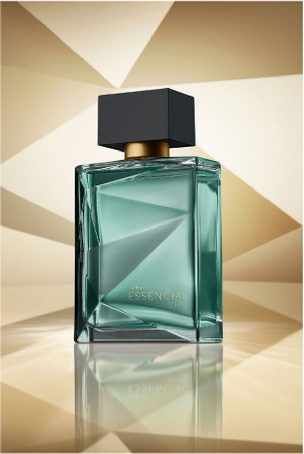 Frasco de Essencial Sentir Masculino, em tom de verde-água e tampa preta, aparece em destaque em fundo dourado multifacetado, fazendo alusão ao design dos frascos de Essencial.