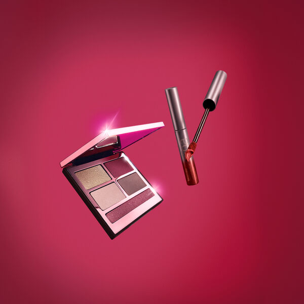 Imagem em fundo rosa escuro com os produtos Batom Líquido Matte Intransferível Una Vermelho-1 e PRO Palette de Sombras Una Rubi.