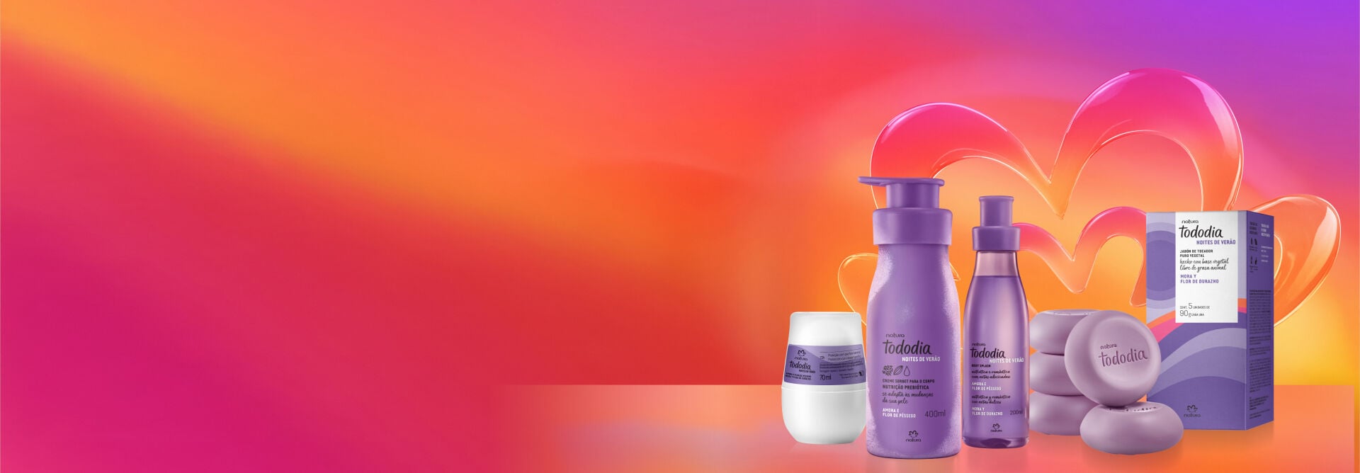 Desodorante Roll-on, Creme Sorbet para o Corpo, Body Splash e Sabonetes em Barra Tododia Amora e Flor de Pêssego, em tom de lilás, destacam-se em fundo degradê rosa e amarelo com a flor símbolo da Natura.