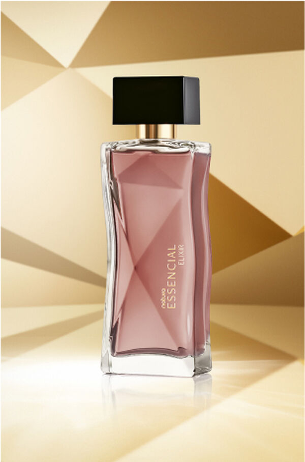 Frasco de Essencial Elixir Feminino, em tons de rosê e tampa preta, aparece em destaque no centro da tela sobre fundo multifacetado dourado, fazendo alusão ao design do frasco de Essencial.