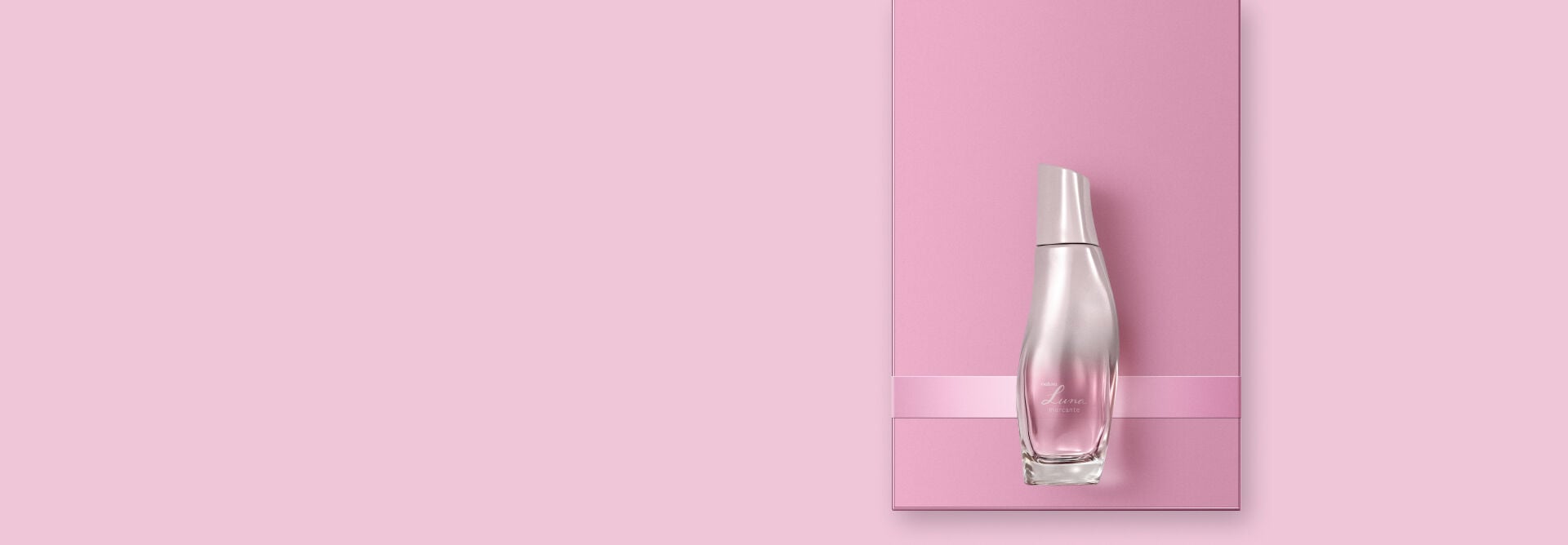 presente Natura Luna, apoiado sobre uma caixa rosa com uma fita rosa, em fundo rosa claro