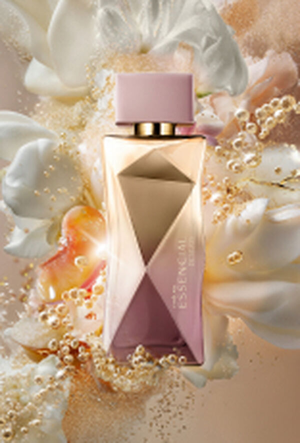 Frasco do Deo Parfum Essencial Desejos Feminino em tons de rosa e dourado sobre flores brancas, damascos e demais elementos que remetem aos ingredientes. Fundo perolado.