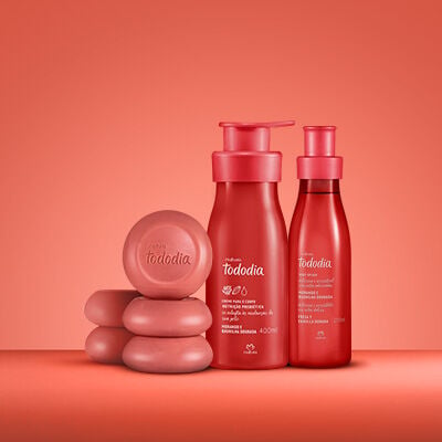 3 produtos da linha Tododia Morango e Baunilha Dourada em fundo vermelho, sendo 5 Sabonetes em Barra, 1 Creme Desodorante Nutritivo para o Corpo e um Body Splash. As embalagens são vermelhas.