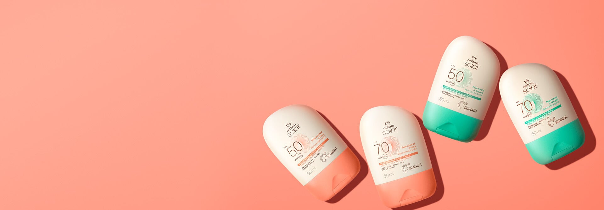 Embalagens Natura Solar Faciais FPS 50 e FPS 70, creme com laranja para pele normal e creme com verde para pele mista, com selo branco circular “Testado Dermatologicamente”, sobre fundo laranja.