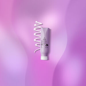 Creme de Pentear Crespos Natura Tododia sobre textura branca do  produto, em fundo roxo.