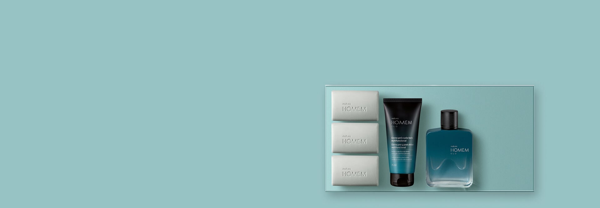 Presente Natura Homem Elo, incluindo 3 sabonetes em barra, 1 creme pré e pós-barba multifuncional e 1 deo parfum, com frascos com efeito degradê azul e preto e tampas pretas, sobre fundo verde-água.