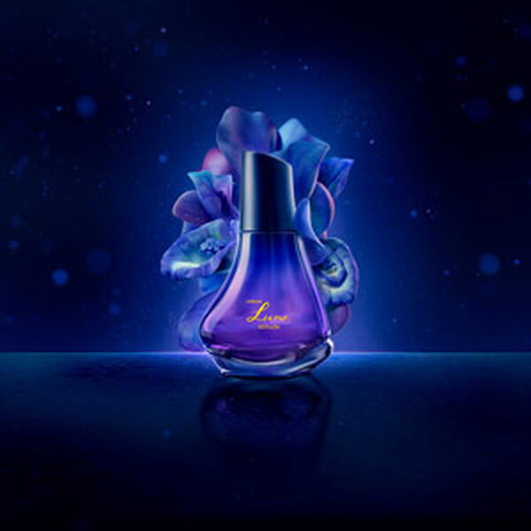 Frasco de Natura Luna Atitude, con una flor azul oscuro detrás del producto y un fondo morado oscuro.