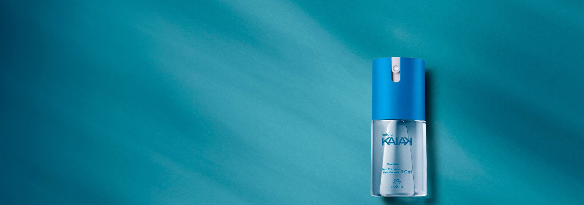Fondo azul con un desodorante en spray Kaiak masculino a la derecha de la imagen.