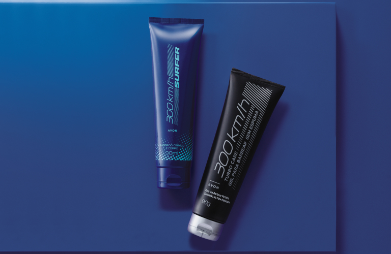 Vista superior de dois tubos de cosméticos, um azul escuro e outro preto, apoiados sobre uma plataforma retangular azul. O fundo é um azul escuro profundo com um reflexo de luz suave no canto superior esquerdo. Os produtos dos tubos são voltados para a rotina diária de cuidados e dicas de como fazer a barba.