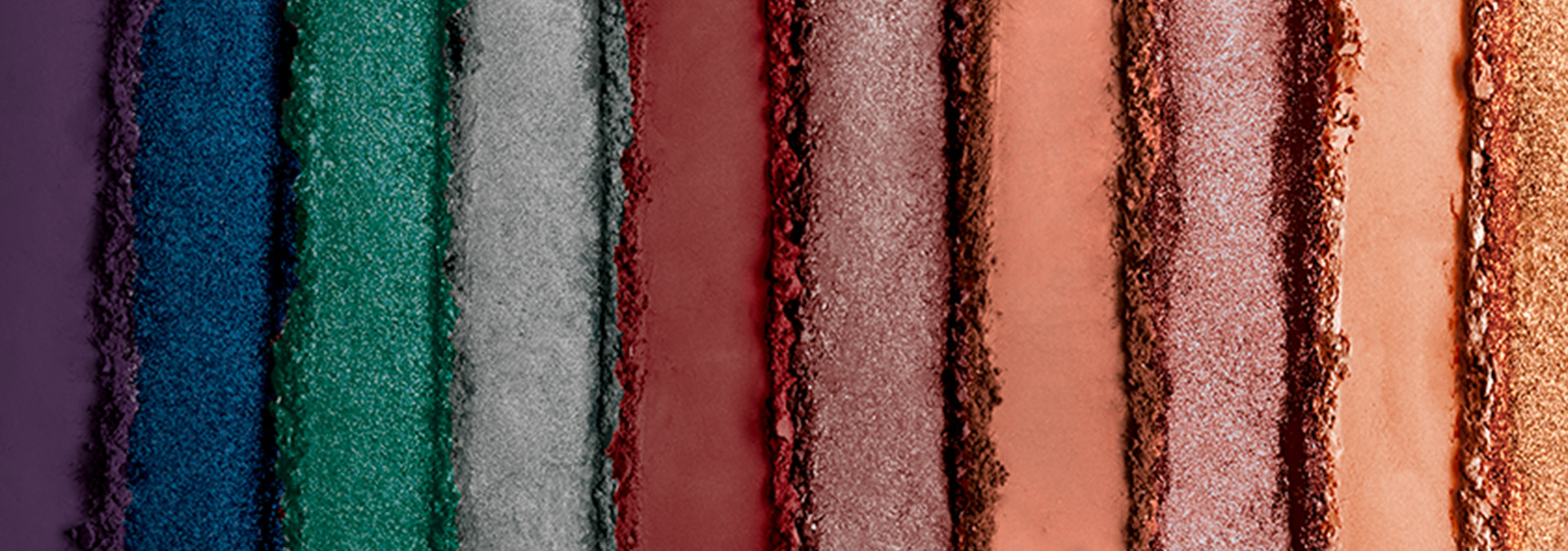 Banner com fundo em tons de roxo, azul, verde e vermelho e outras cores, apresentando sombras em pó. O texto sugere transformar o olhar com texturas suaves e durabilidade para qualquer ocasião.