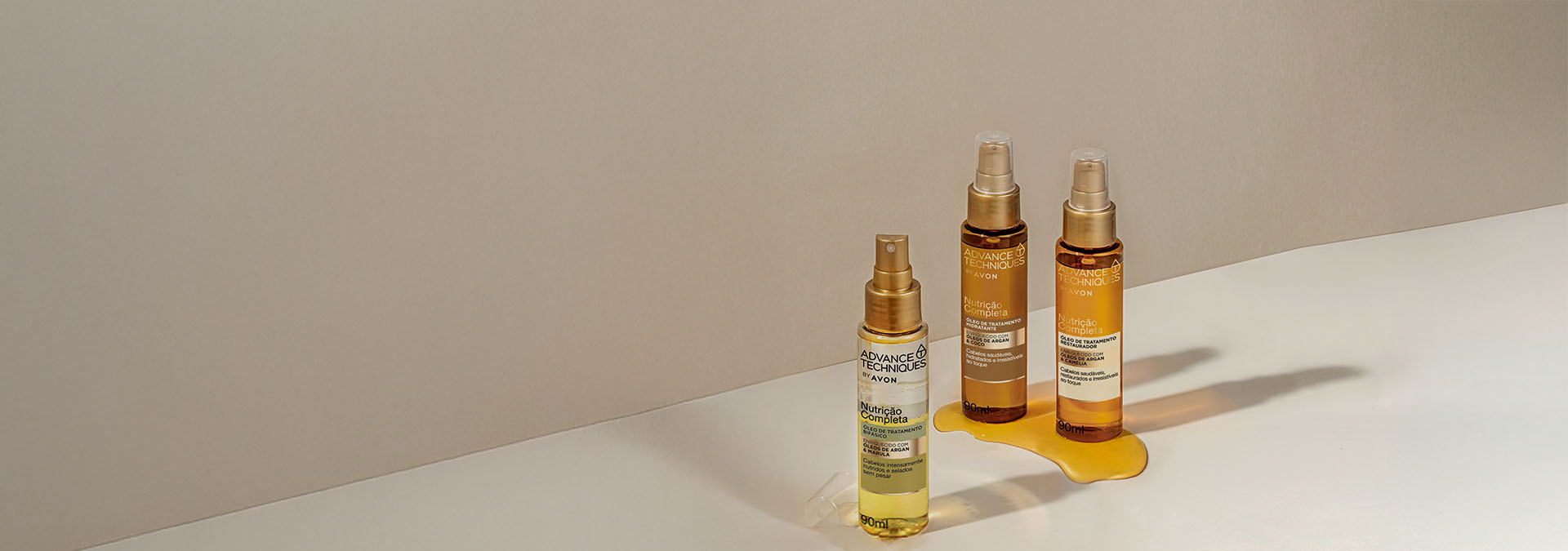 Banner em fundo bege. Em destaque, três frascos de sérum e óleo capilar, com um dos óleos derramado. Texto: "Cabelos impecáveis, sem frizz e super macios! Descubra o segredo com nossos produtos."