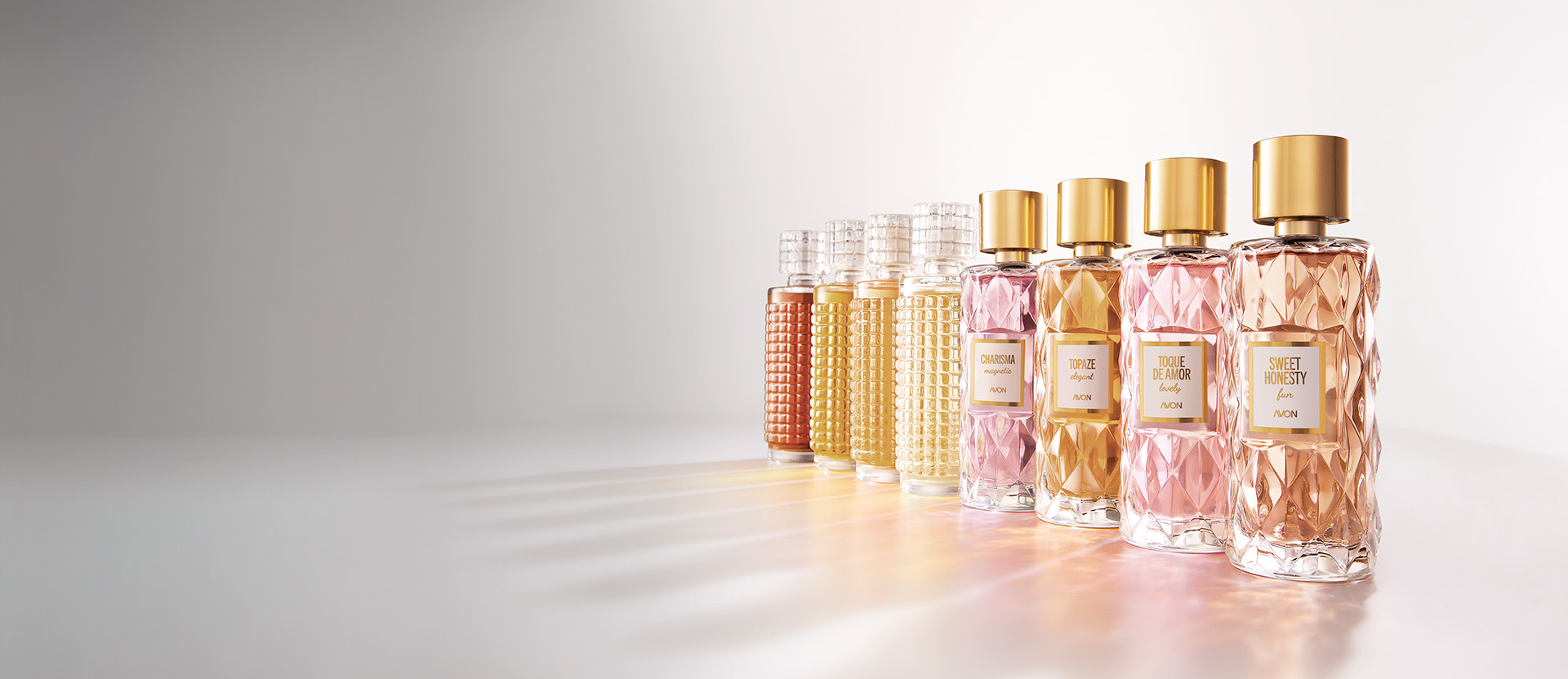 Frascos de Aquavibe Body Splash: Romã, Framboesa, Pretty Blue, Nectarina e Flor de Pêssego, Ameixa, Jabuticaba, Baby Smell, Lichia e Baunilha, Pitanga e Chipre, sobre fundo aquoso azul.