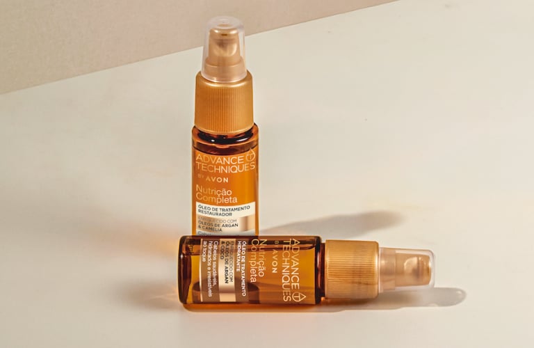 Cinco frascos de óleo capilar Advance Techniques Avon alinhados sobre fundo claro, com amostra do produto dourado e fluido.