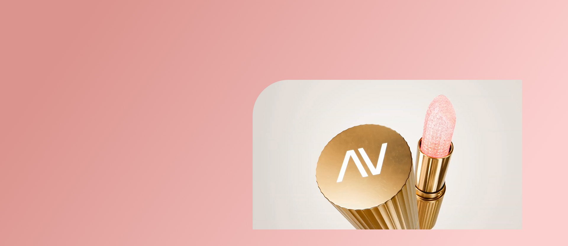 Vídeo inicia com batom com embalagem dourada estriada e tampa com as letras AV em branco, e bala rosa clara texturizada, seguido de transição para imagens de mulher de vestido rosa e cabelos presos segurando e passando o batom. Finaliza com a embalagem dourada do batom sendo fechada. Fundo bege com moldura em rosa.