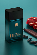 Fragrância Black Essential Secret com ingredientes como maçã, couro e sementes, em fundo verde.
