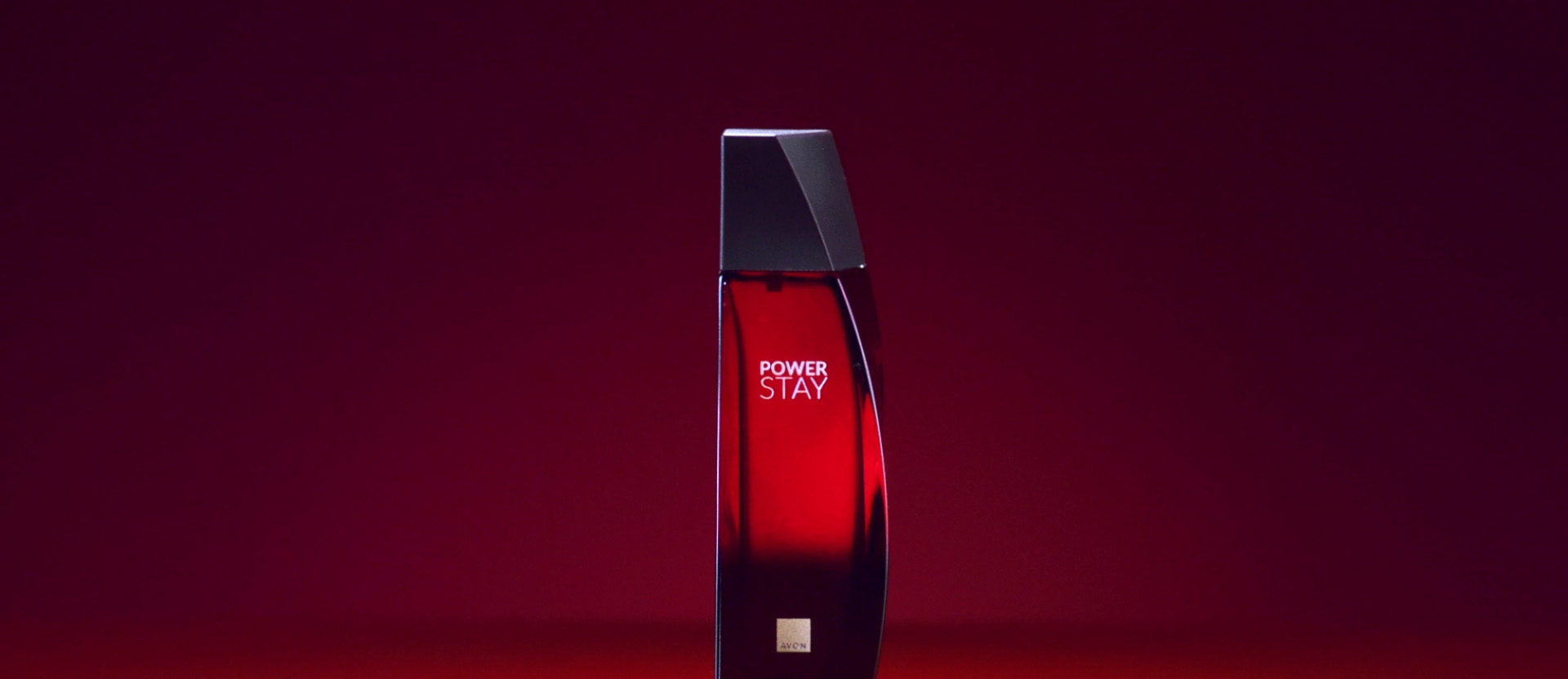 Vídeo Power Stay com fundo vermelho. Mulher com batom e vestido vermelhos aplica  fragrância Power Stay no pescoço e interage com flor vermelha. Transição para flores e frutas vermelhas,  como mirtilos e framboesas. Finaliza com frasco de fragrância Power Stay vermelho com tampa preta.