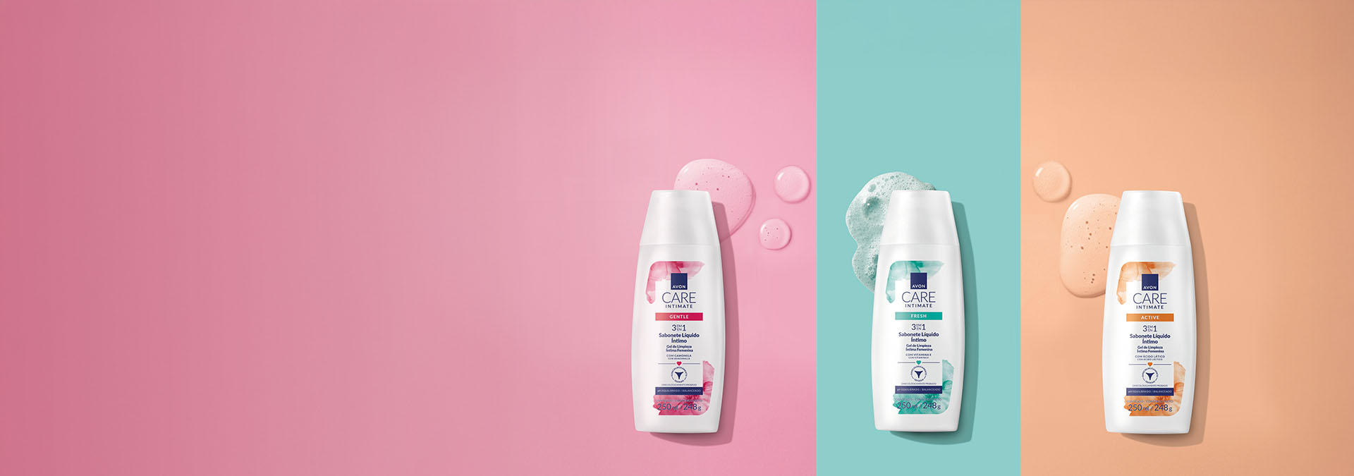 Banner com fundo rosa, azul e laranja, apresenta três frascos de sabonete íntimo, acompanhados de gotas do produto. Texto: "Sabonete para uma limpeza eficaz e suave, cuidando da sua saúde."