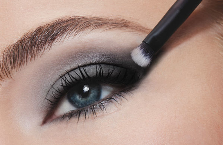 Mulher utilizando sombra esfumada da Paleta Silver da Avon para uma maquiagem de madrinha, destacando o olhar em tons de cinza e preto.